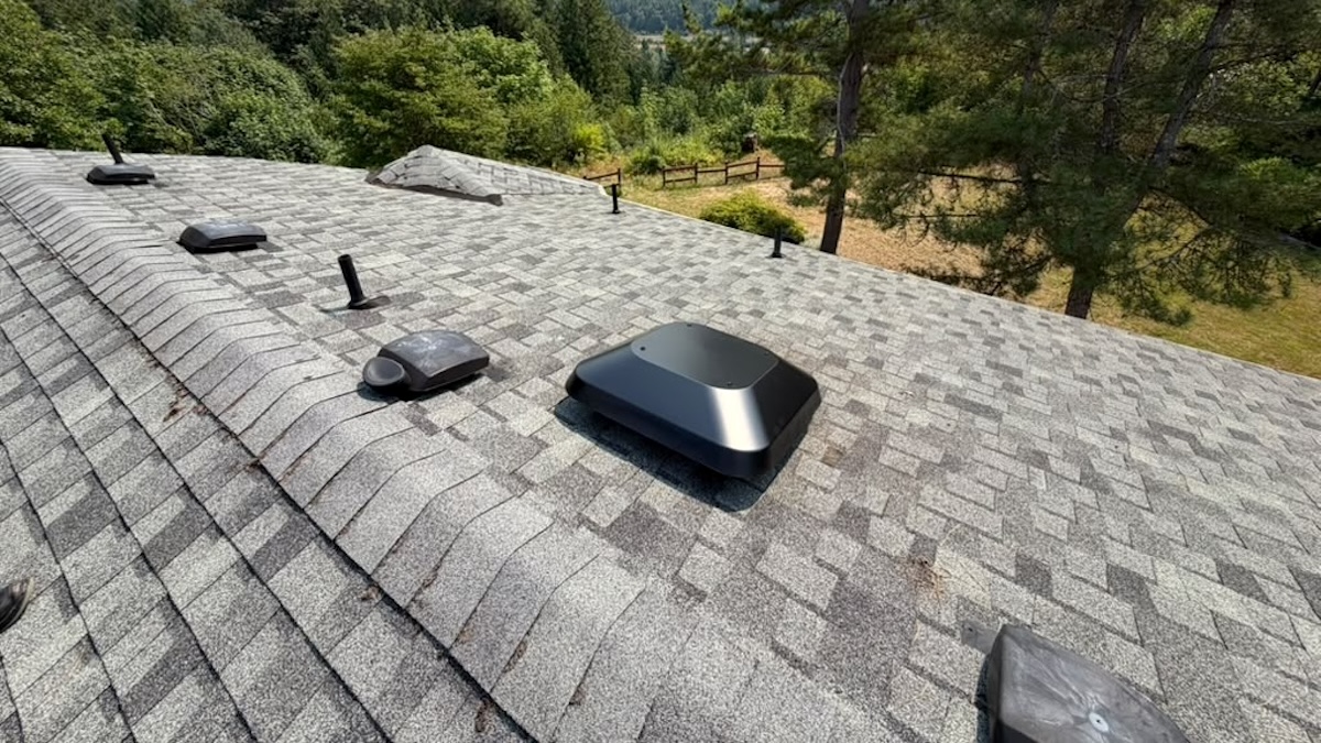 Electric Attic Fan Installed On A Two-Story Residence's Shingle Roof